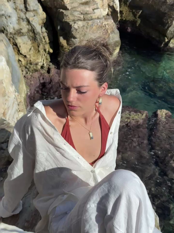 Video showing model wearing our Dusk drop pendant necklace and earrings. The ceramic jewellery features smoky purple glass with gold lustre detailing. 