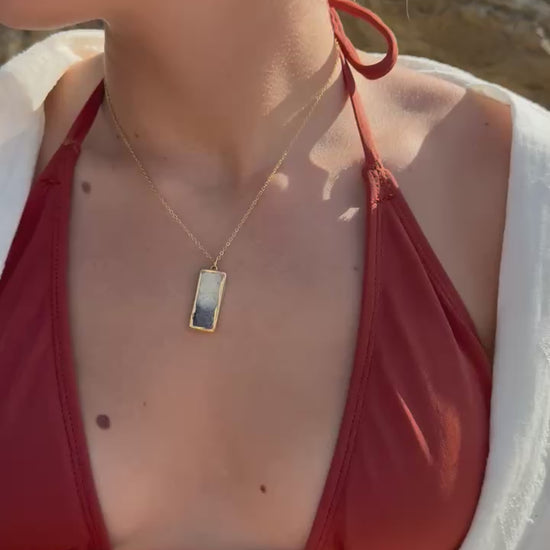 Video showing a range of our Dusk Jewellery pieces: the drop pendant on a gold chain, the drop earrings and our adjustable ring. The pieces combine ceramic and glass elements with gold lustre detailing. 