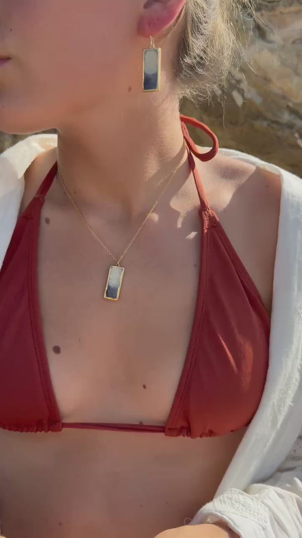 Video showing a range of our Dusk Jewellery pieces: the drop pendant on a gold chain, the drop earrings and our adjustable ring. The pieces combine ceramic and glass elements with gold lustre detailing. 