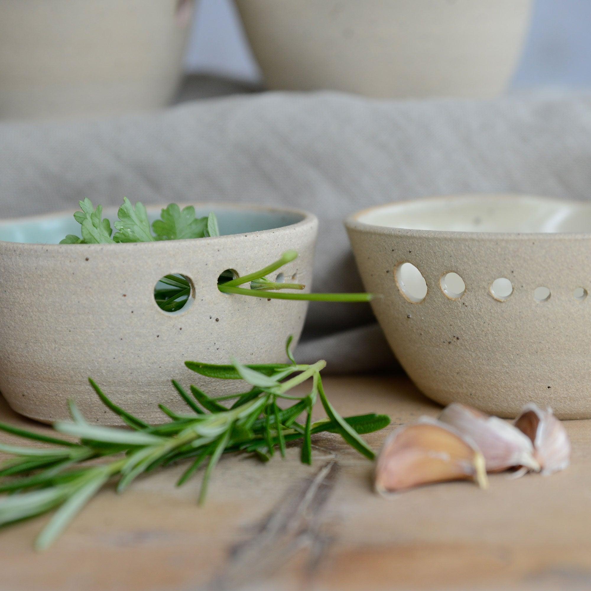 Close up of herbs being passed through the holes on the bowl