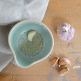 Above view of a garlic clove that has been grated inside the bowl