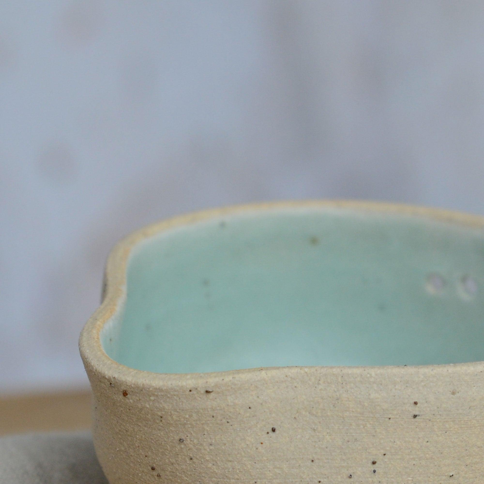 Close up flecked stoneware spout and green glaze