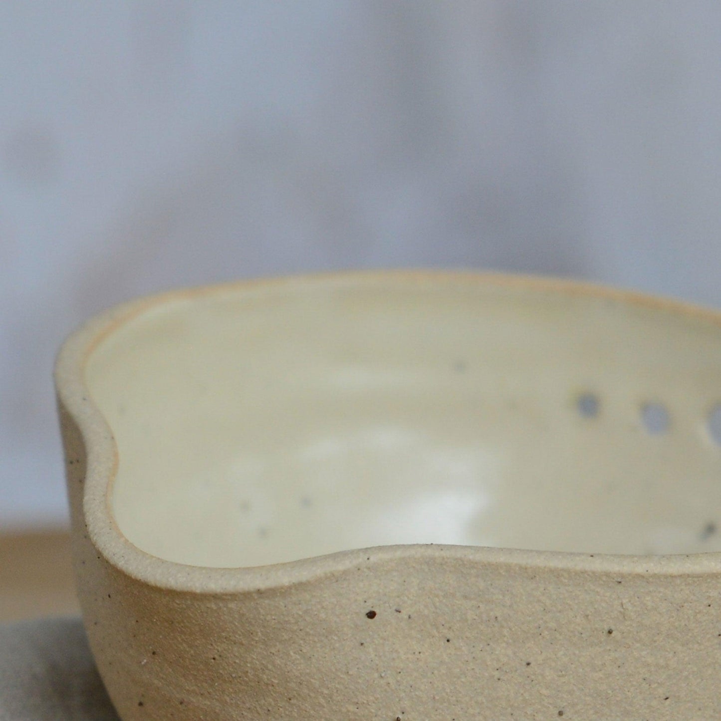 Close up flecked stoneware spout and yellow glaze