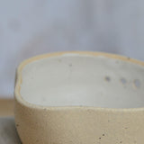 Close up flecked stoneware spout and white glaze