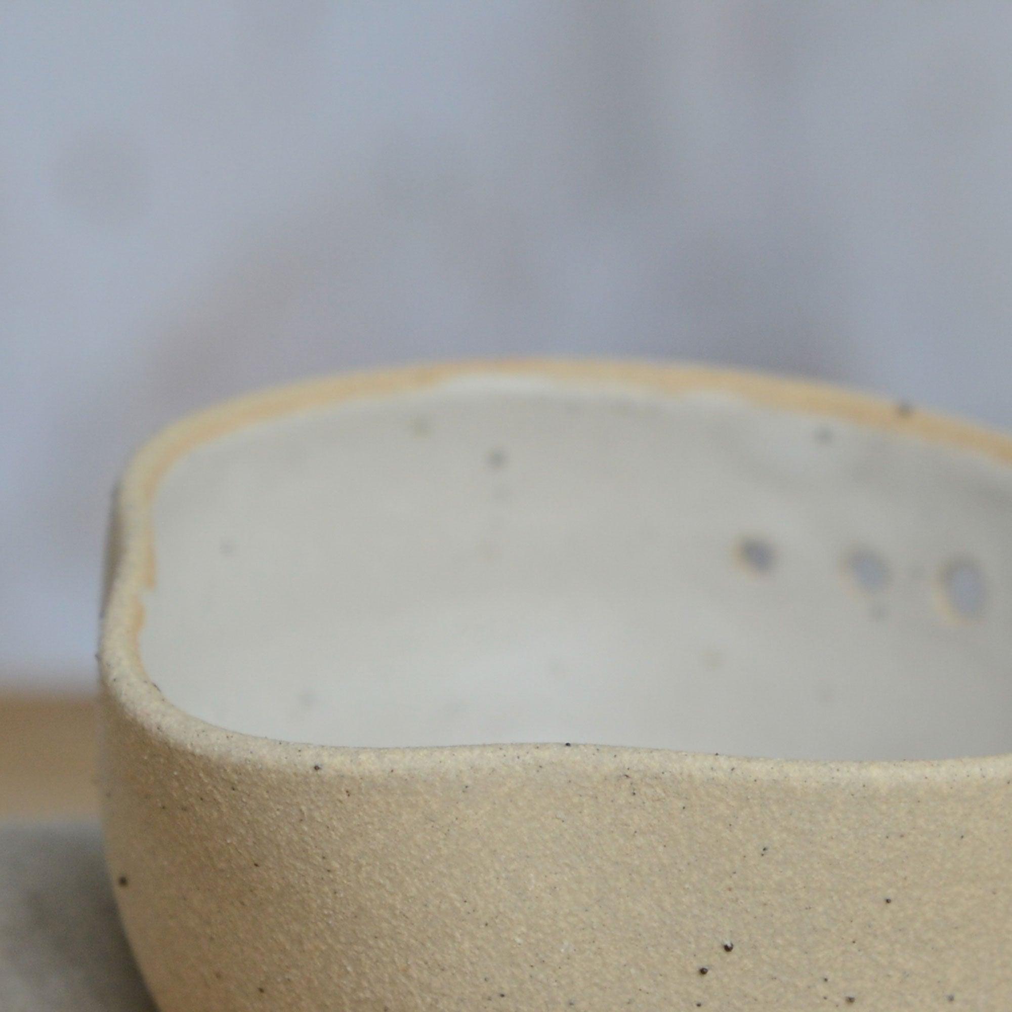 Close up flecked stoneware spout and white glaze