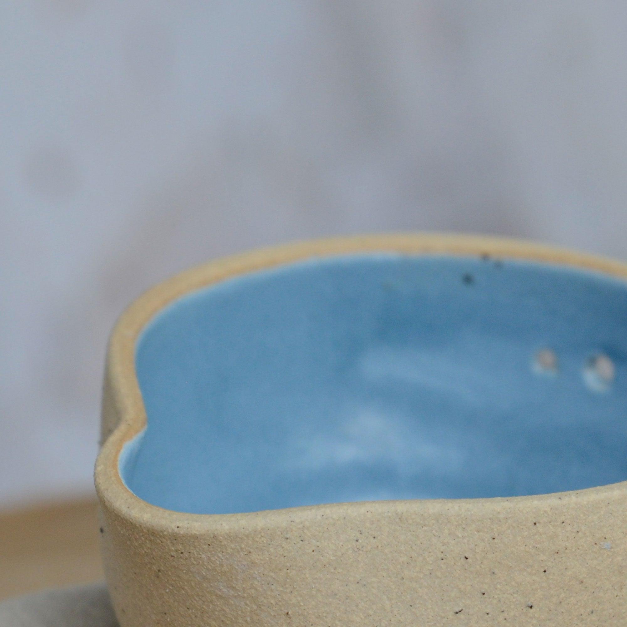 Close up flecked stoneware spout and blue glaze