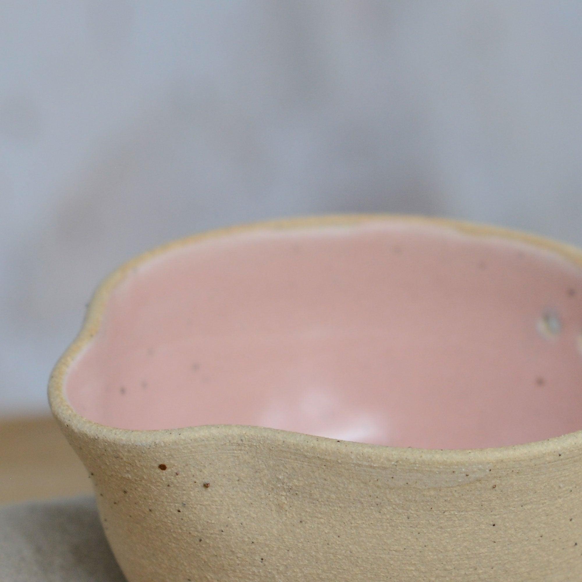 Close up flecked stoneware spout and pink glaze