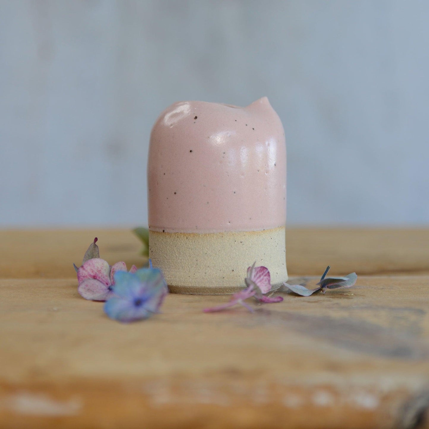 Close up of flecked stoneware and pink glaze on small jug