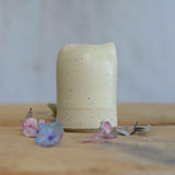 Close up of flecked stoneware and yellow glaze on milk jug