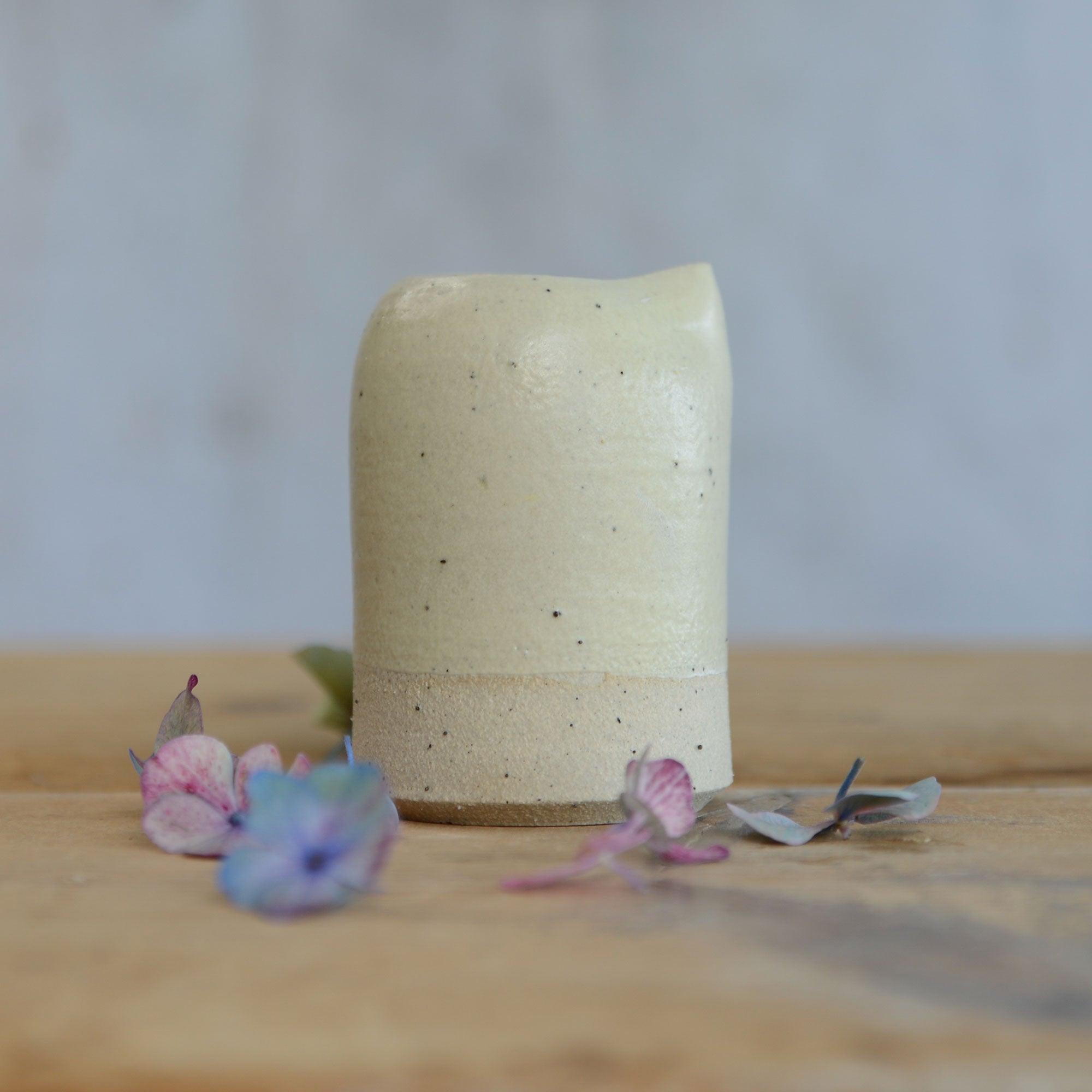 Close up of flecked stoneware and yellow glaze on milk jug