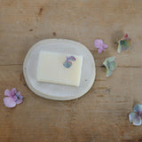 Small white soap dish with soap for size reference