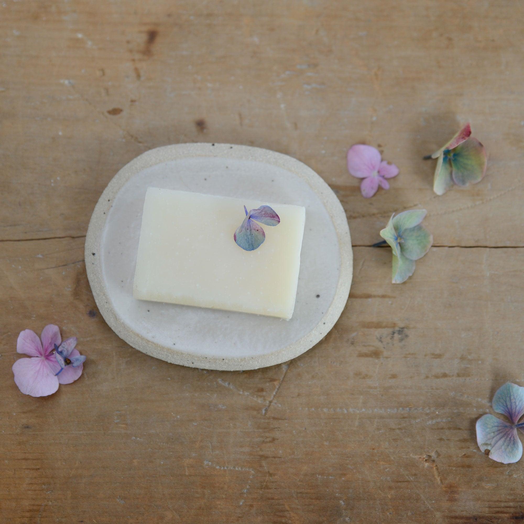 Small white soap dish with soap for size reference