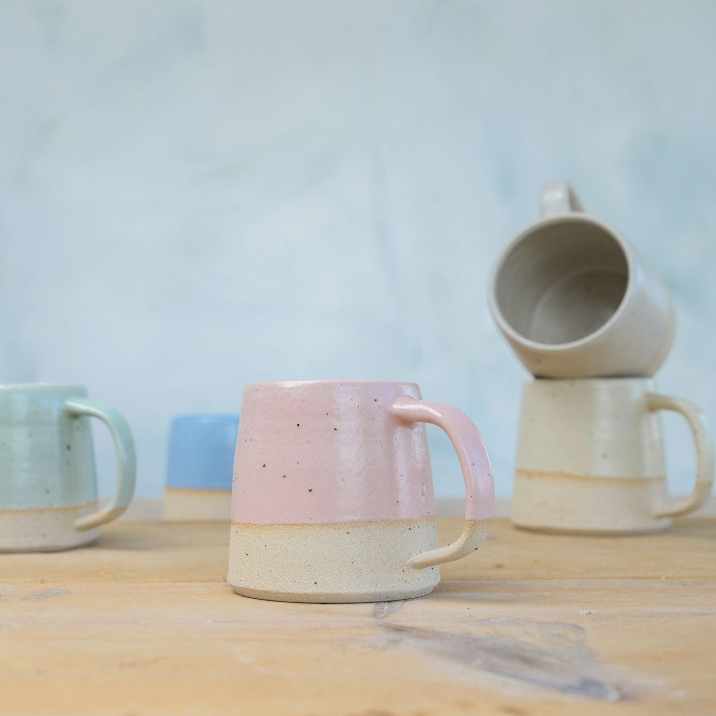 Pale Pink Mug in front of pastel coloured mugs on table