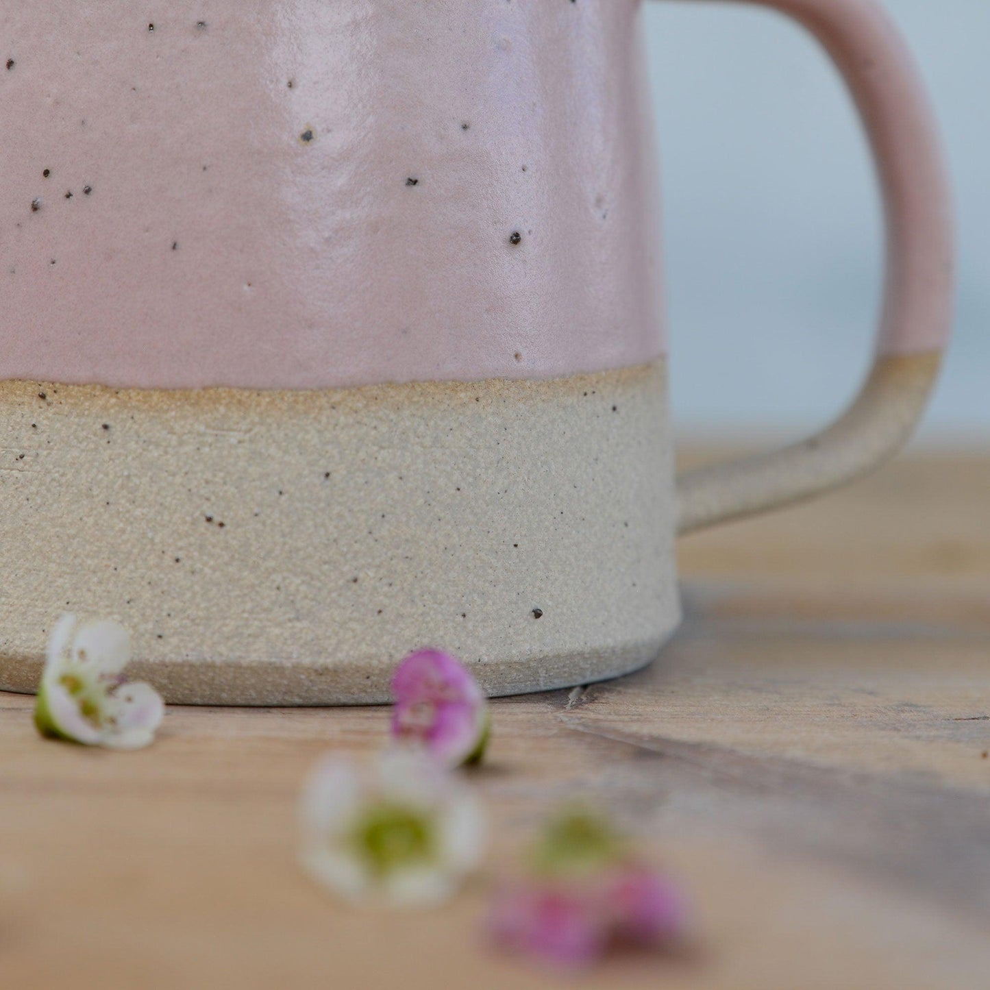 Close up of flecked clay texture and smooth pink glaze