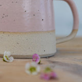 Close up of flecked clay texture and smooth pink glaze