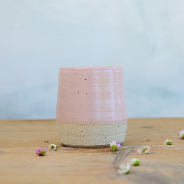 Close up of flecked stoneware and pink glaze on tumbler