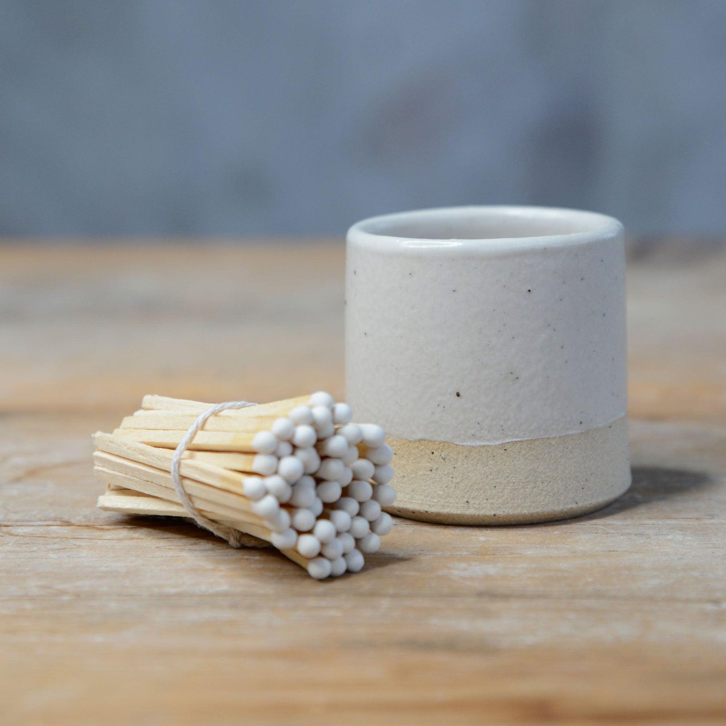 Bundle of white matches lying next to white match pot