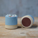 2 blue match pots, one on its side showing the underside striker pad
