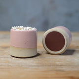 2 pink match pots, one on its side showing the underside striker pad