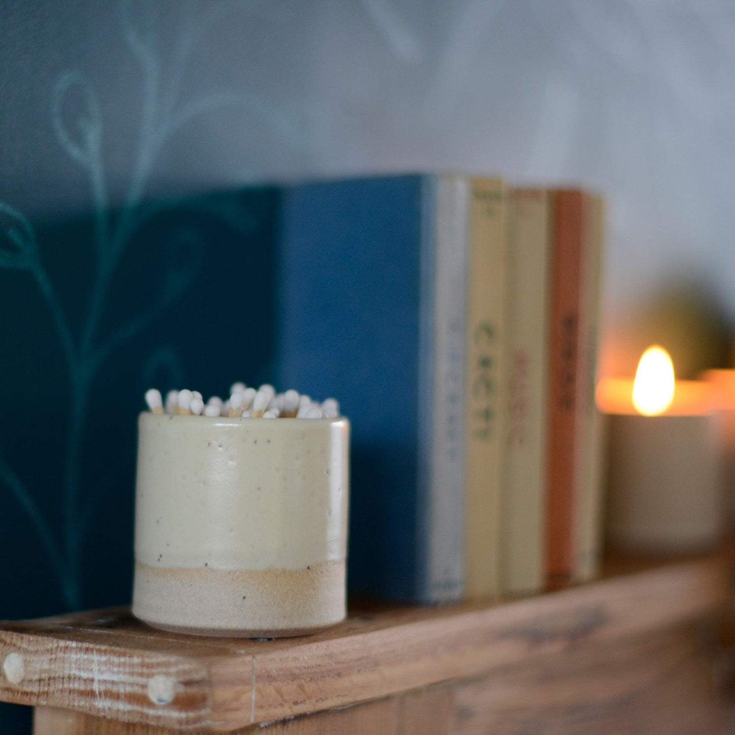Match pot on mantle piece next to old books