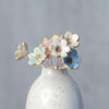 Close up of pastel ceramic flower heads in white vase