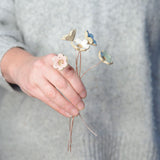 Hand holding all 5 pastel ceramic flowers