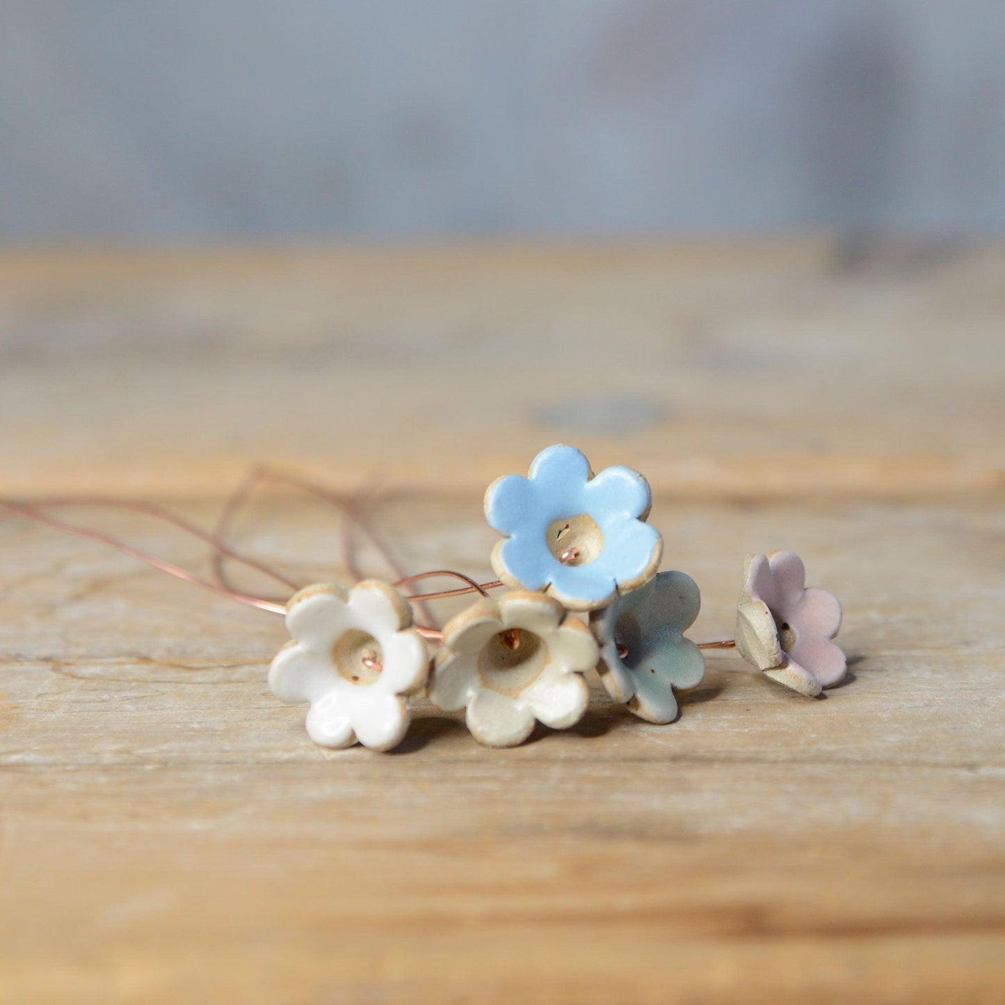 5 Pastel coloured flowers lying on table