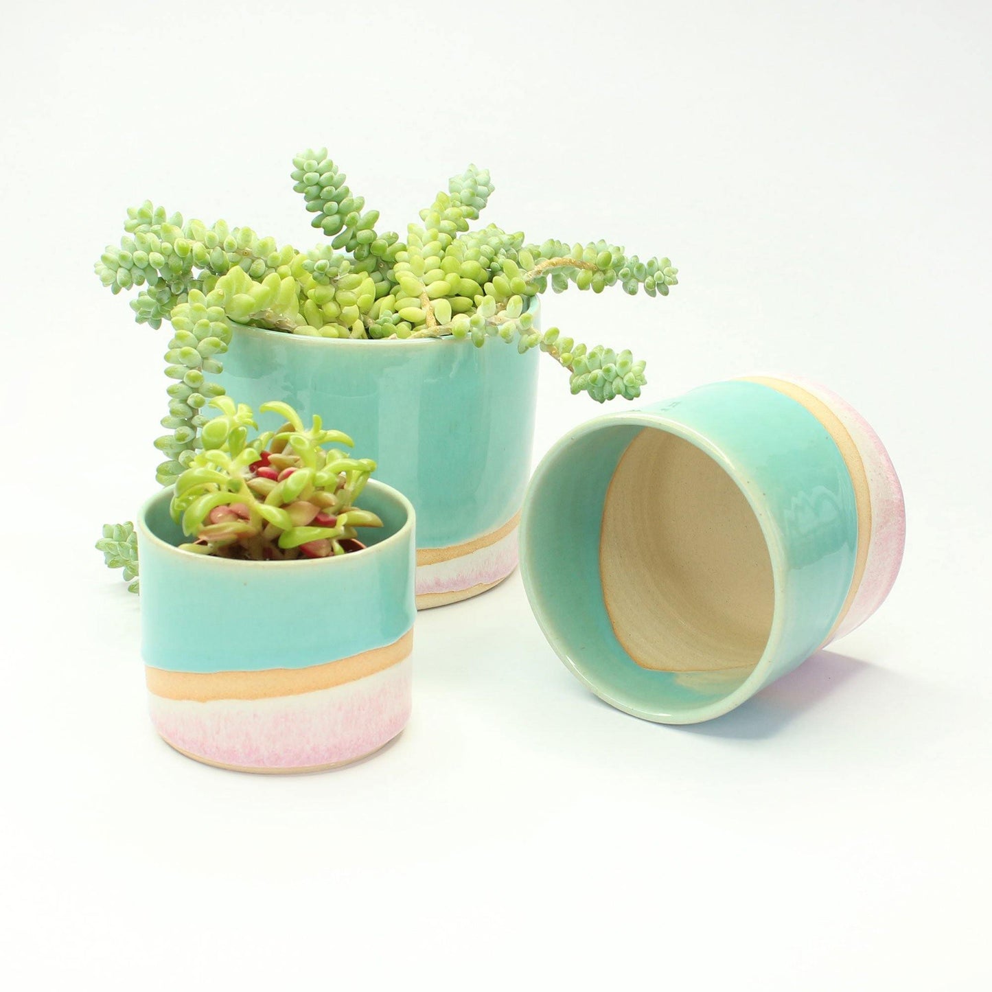 Set of 3 Shoreline planters from different angles, one on its side showing the raw clay interior