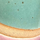 Close up of natural clay flecks coming through the blue and pink glazes