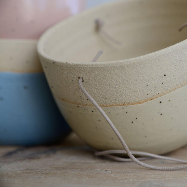 Close up of flecked stoneware, yellow glaze and cord on planter