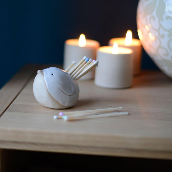 Bird Match Striker Pot in Off-White Stone on mantlepiece with lit candles