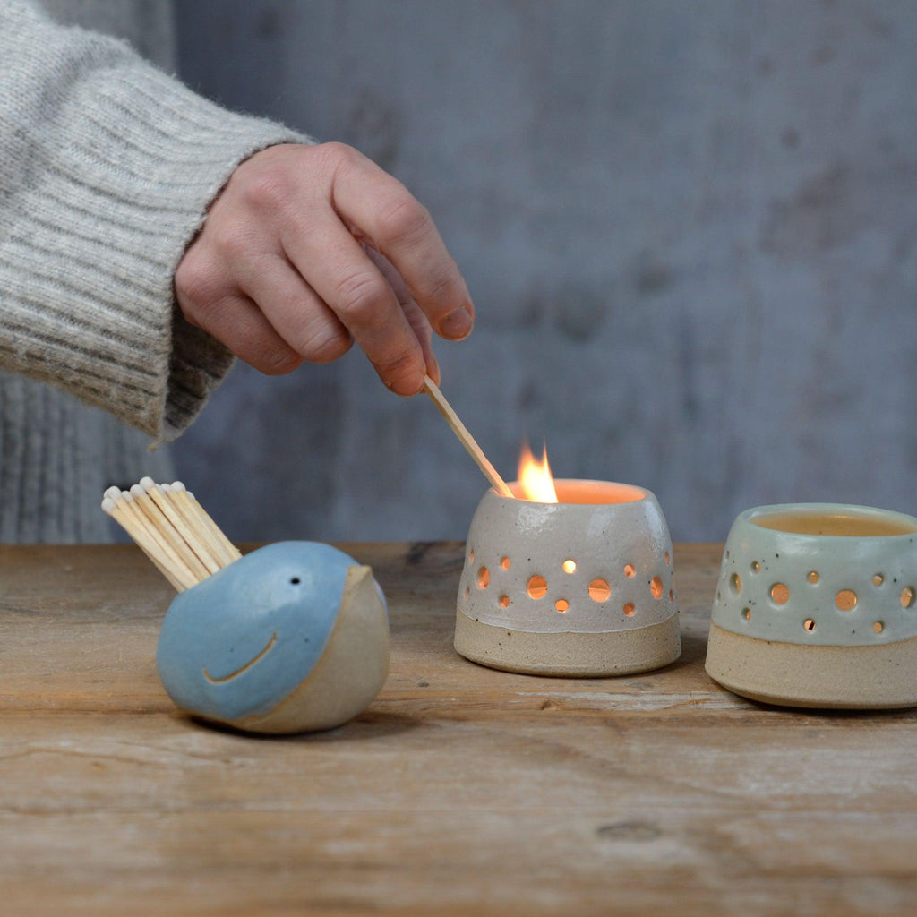 Matches from blue bird match pot being used to light tealight