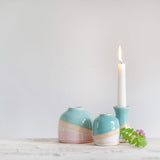 A Shoreline dome and mini vase next to a shoreline candle holder with a lit candle in.
