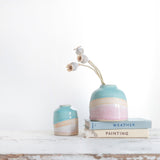 Mini Shoreline dome vase filled with three dried poppy head stems on a couple of pastel vintage books, a mini shoreline vase sits to the left.Shoreline - Habulous